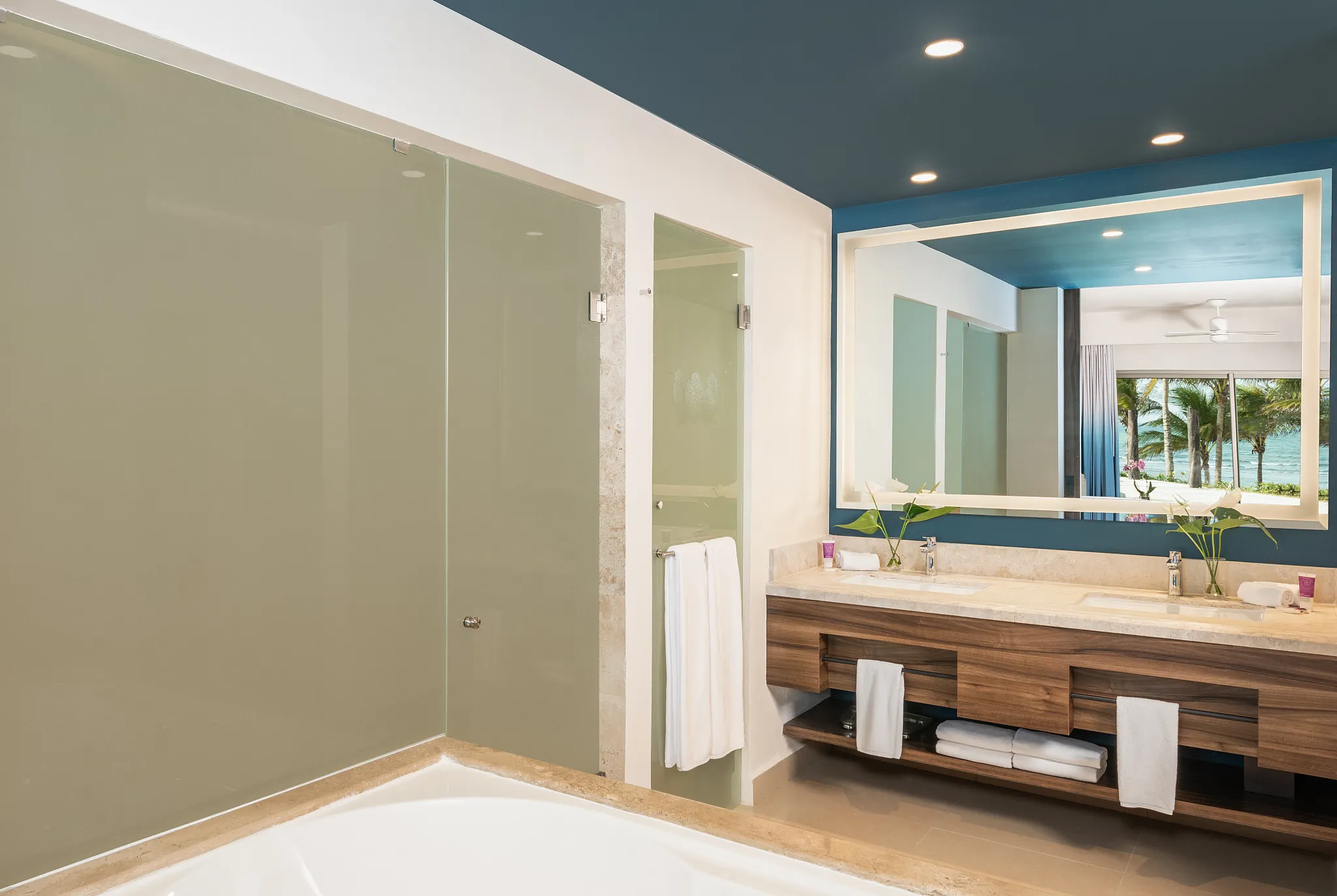 Junior Suite Waterpark View Double bathroom with double sinks and glass shower at Dreams Puerto Morelos Resort.