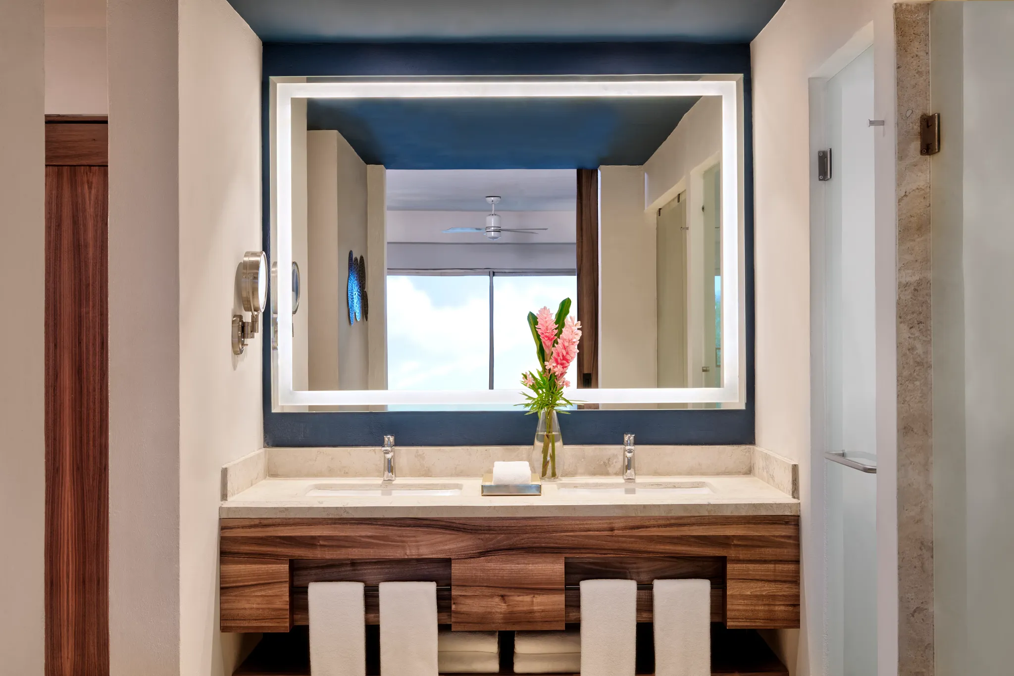 Preferred Club Junior Suite Ocean View bathroom with double sinks and illuminated mirror at Dreams Puerto Morelos Resort.