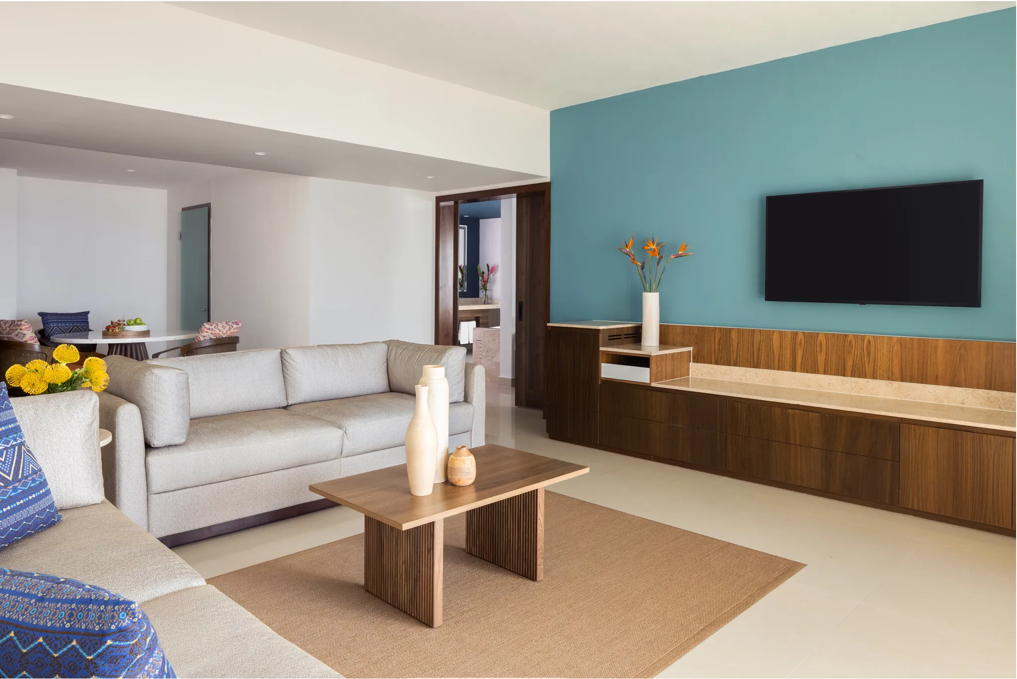 Preferred Club Master Suite Ocean Front living room with sofa seating and TV at Dreams Puerto Morelos Resort & Spa.