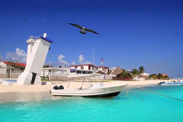 Puerto Morelos Beach near Dreams Puerto Morelos Resort & Spa with turquoise water, boats, and coastal village views