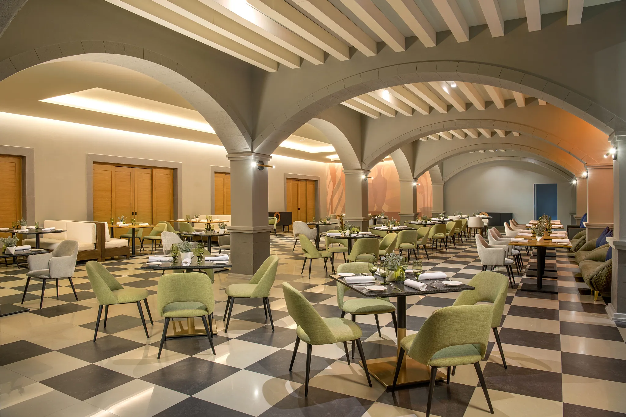Vivace Italian restaurant at Dreams Puerto Morelos Resort & Spa featuring elegant arched ceilings, checkered floors, and modern Mediterranean dining décor.